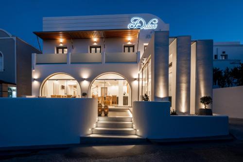 费拉Deluxe Hotel Santorini的一座白色的大建筑,晚上有灯