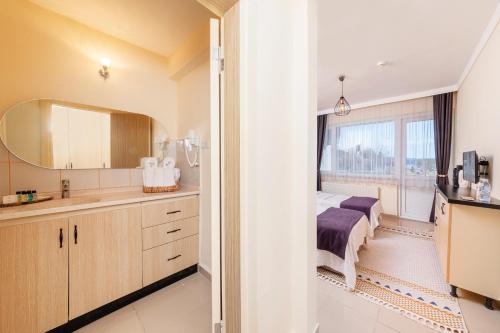 埃尔代克KİRAZ BEACH OTEL的一间卧室配有床、水槽和镜子