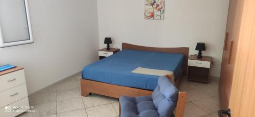 托雷拉皮罗Casa Domenica的一间小卧室,配有一张床和一张蓝色椅子