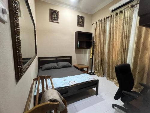 哥打巴鲁Homestay Rohmat的一间卧室配有一张床、镜子和椅子