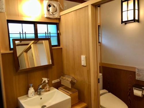 岛田Kappo Ryokan Uoichi的一间带水槽、卫生间和镜子的浴室