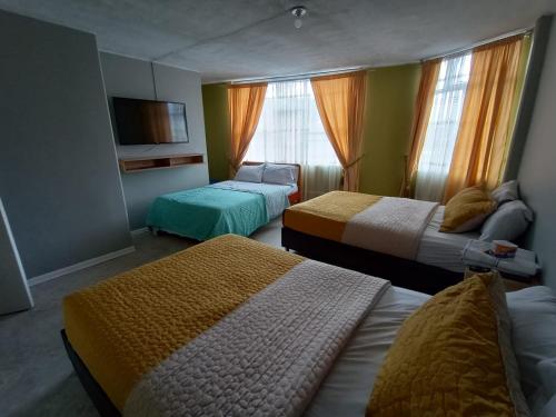 帕斯托HOTEL DINO的酒店客房设有两张床和电视。