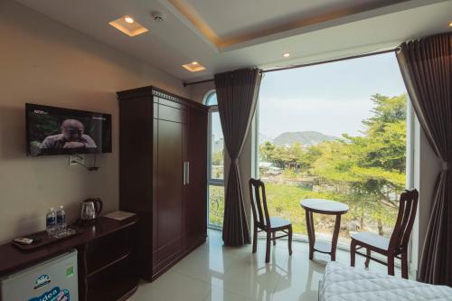 头顿Biển Vàng - New Golden Sea的客房设有大窗户、桌子和椅子。