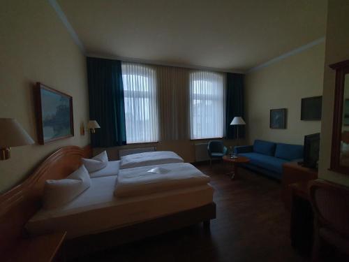 拉特诺福斯特霍夫酒店的酒店客房,设有两张床和一张蓝色的沙发