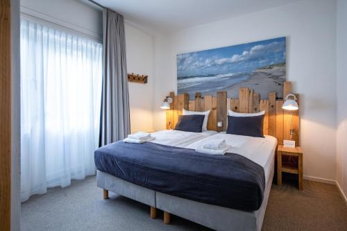 德瓦尔B&B Hotel De Waal的一间卧室配有一张大床和木制床头板
