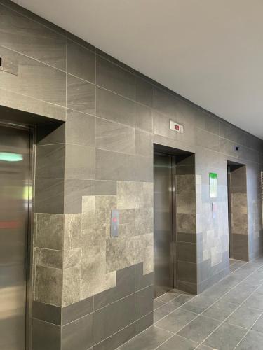 蕉赖Sheera Islamic Homestay 2r2bathroom Free Wifi with tv channels Netflix Coway Water的大楼里设有三部电梯的大堂
