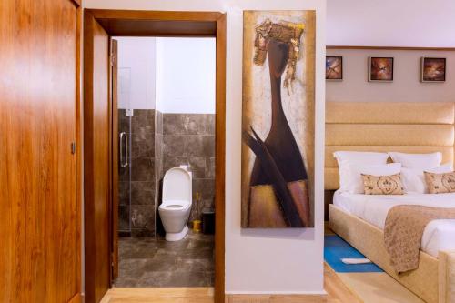基加利传奇精品酒店 的一间卧室配有一张床,浴室设有卫生间