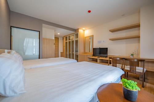 清迈Rain Tree Condominium的酒店客房设有两张床和一台平面电视。