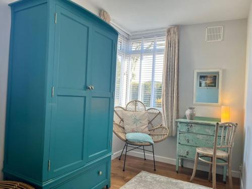 Blue AnchorBlue Anchor House - Seaview, Hot Tub Apartments的蓝色的橱柜,配有椅子和书桌