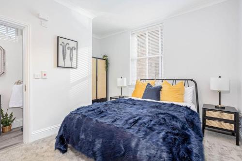 格里姆斯比Coppergate Mews Grimsby No.3 - 2 bed, 2 bath, ground floor apartment的一间卧室配有一张带蓝色棉被和黄色枕头的床