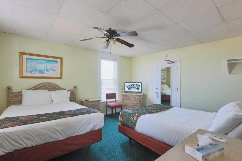 大洋城Shoreham Oceanfront Hotel的酒店客房配有两张床和吊扇。