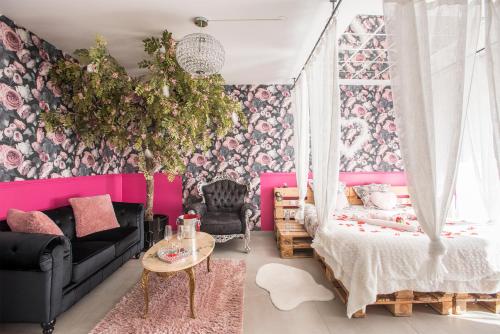 第戎Romantisme et glamour 2 avec spa , clim et jardin的一间卧室配有一张床和粉红色的墙壁