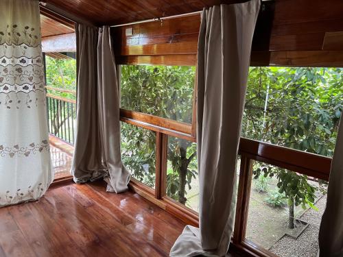 Tuxtla ChicoQuinta Esperanza的客房设有大窗户 和木地板