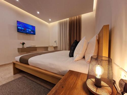 拉纳卡Sveltos Residence Suites的卧室配有一张大床,墙上配有电视