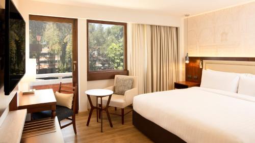 普埃布拉普埃布拉梅松德尔安赫尔万豪酒店的配有一张床、一张书桌和一扇窗户的酒店客房