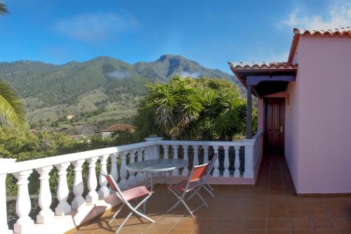 埃尔帕索Casa Rural Olga的阳台配有桌椅,享有山景。
