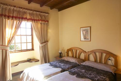 埃尔帕索Casa Rural Olga的一间卧室设有两张床和窗户。