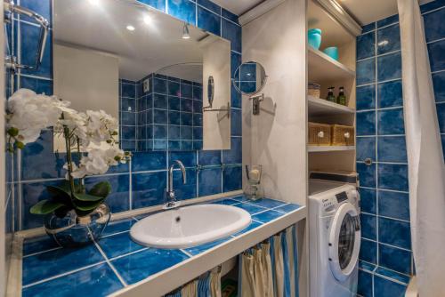 尼斯Samourai Massena Lodge -1 min from the sea的蓝色瓷砖浴室设有水槽和洗衣机