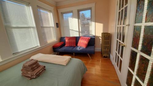 波士顿Near Train Station Gorgeous 3-Bedroom Apartment with Patios的客房设有床、沙发和窗户。