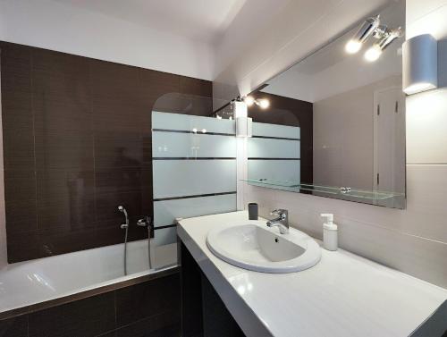 雅典Menelaou by Verde Apartments的浴室配有盥洗盆、镜子和浴缸