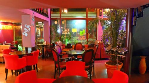 莫姆奇尔格勒Hotel Berito的一间餐厅,房间内设有红色的椅子和桌子