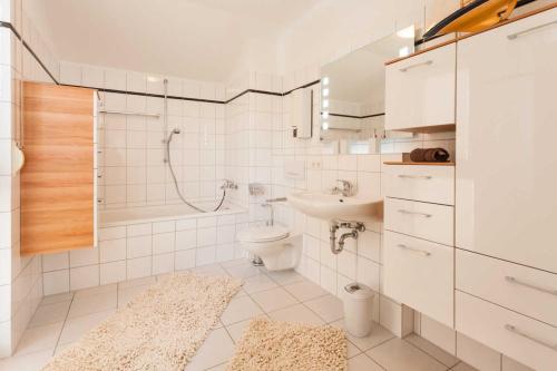 萨斯尼茨Penthouse Saphir mit Meerblick的浴室配有盥洗盆、卫生间和浴缸。