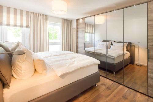 萨斯尼茨Penthouse Saphir mit Meerblick的一间卧室设有两张床和玻璃墙