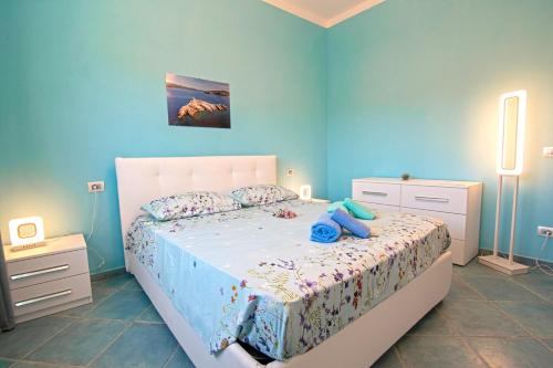 费拉约港Appartamenti Mare Portoferraio的卧室配有白色床和蓝色的墙壁