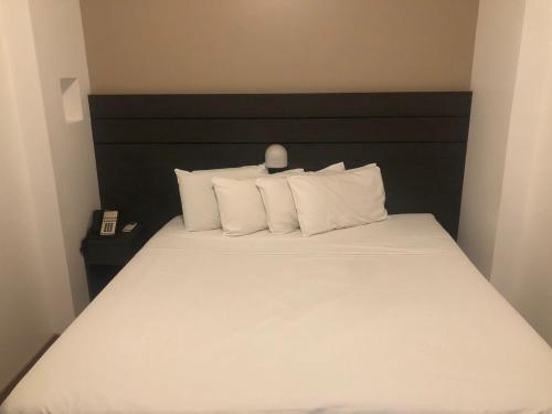 贝洛奥里藏特San Diego Apart- Hotel的一间卧室配有带白色床单和枕头的床。