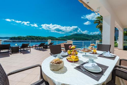 杜布罗夫尼克Villa Vacanza Dubrovnik - Five Bedroom Villa with Private Sea Access的阳台上的餐桌和食物,享有海景
