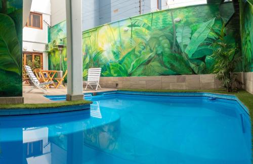 利马Rainbow Hostel的一座建筑的一侧,设有一座带壁画的游泳池