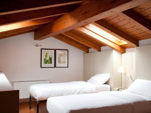 贝拉吉奥Nenè-Il Vicolo Apartments and Rooms的配有木天花板的客房设有两张床。