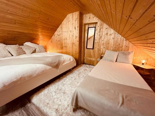 HergersweilerBrenner‘s Waldhaus的小木屋内一间卧室,配有两张床
