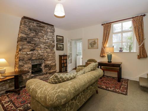 卡特梅尔Longlands Groom's Quarters的带沙发和石制壁炉的客厅