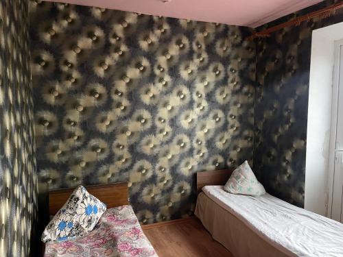 雷泽克内Nakts zvaigzne的一间卧室设有两张床,墙上贴有壁纸。