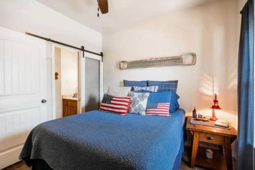 新布朗费尔斯Guadalupe Getaway的一间卧室配有蓝色的床和红色的白色和蓝色的枕头