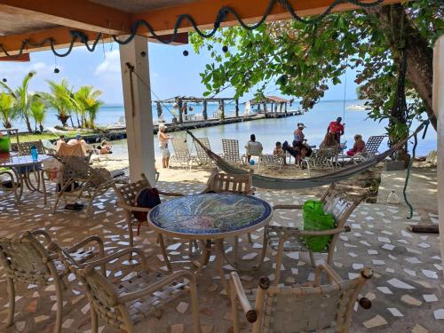 波托韦洛Villa Bella的海滩上带桌椅和吊床的天井