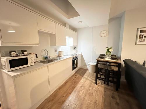 梅德斯通Homes from home by Tulloch Properties的厨房配有白色橱柜和微波炉