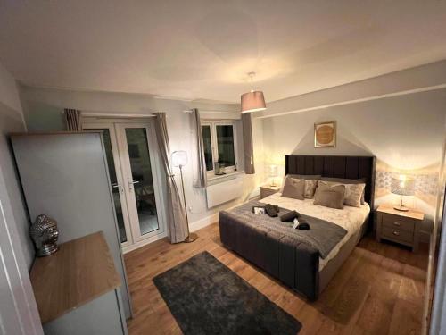 梅德斯通Homes from home by Tulloch Properties的一间卧室设有一张大床和两个窗户。