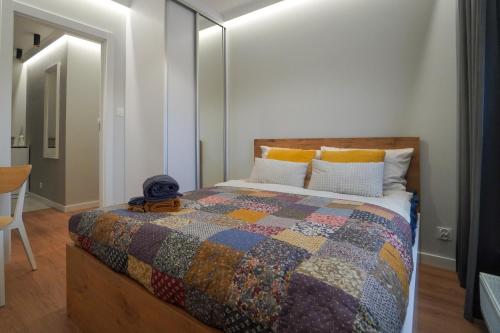 普沃茨克Apartament Manhattan的一间卧室配有一张带五颜六色被子的床