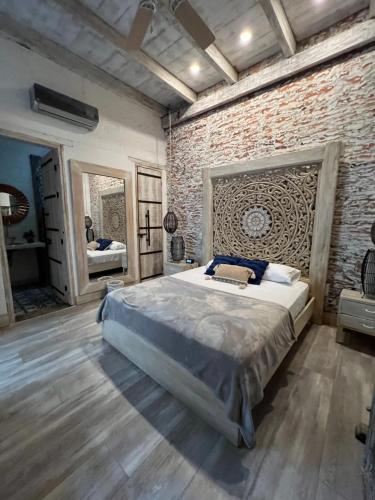 卡利MAHI CASA BOUTIQUE的卧室设有一张砖墙内的大床