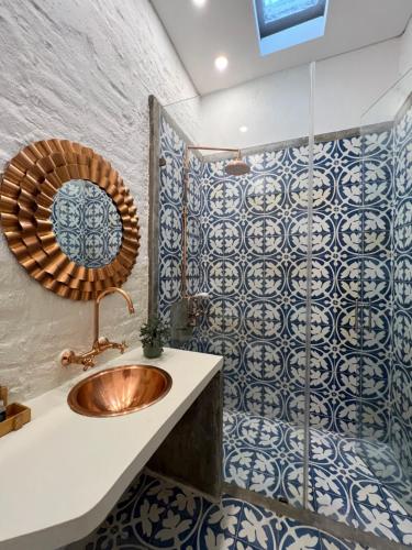 卡利MAHI CASA BOUTIQUE的浴室设有水槽和蓝色及白色瓷砖