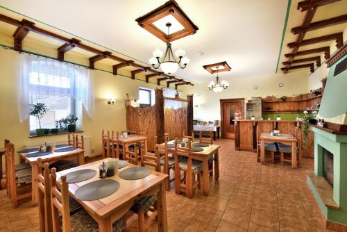 韦尔卡鲁穆尼卡Penzión Víchrica的餐厅设有木桌、椅子和壁炉