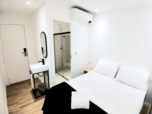 圣保罗Capsula Hotel Sao Paulo - Paulista的卧室配有白色的床和镜子