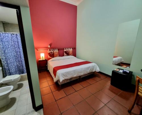 萨尔塔雷富希奥德尔印加酒店的一间卧室配有一张床,浴室设有卫生间