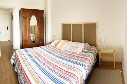 蒙得维的亚Apartamento céntrico的一间卧室配有一张大床和色彩缤纷的毯子