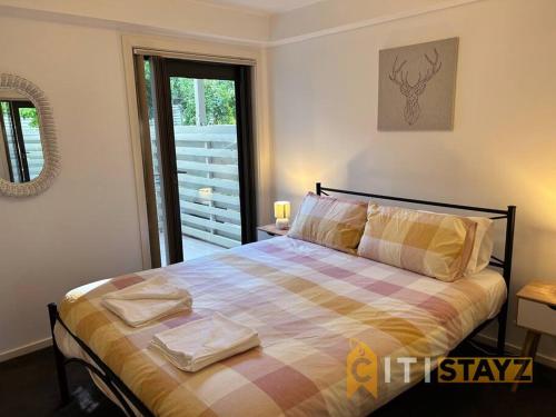 贝尔康嫩Relaxing Oasis in Bruce -1bd 1bth 1 carsp Apt的一间卧室配有一张带 ⁇ 子毯子的床