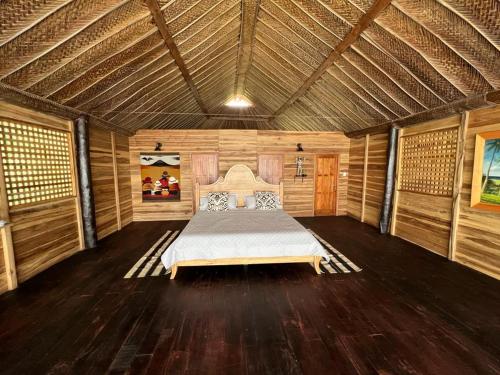 圣玛尔塔Hostal velero relax的木制客房内的一间卧室,配有一张床