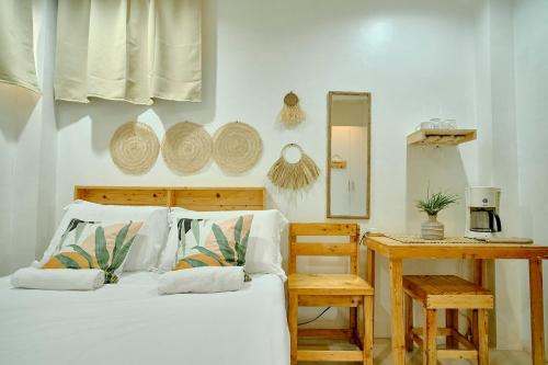 伊洛伊洛Pallet Homes - Gran Plains的一间卧室配有一张床、一张桌子和一面镜子