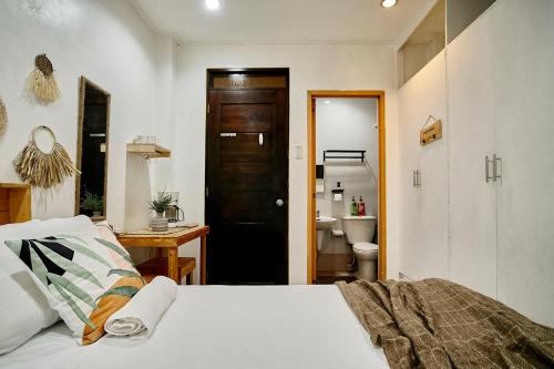 伊洛伊洛Pallet Homes - Gran Plains的一间卧室配有一张床,浴室设有卫生间
